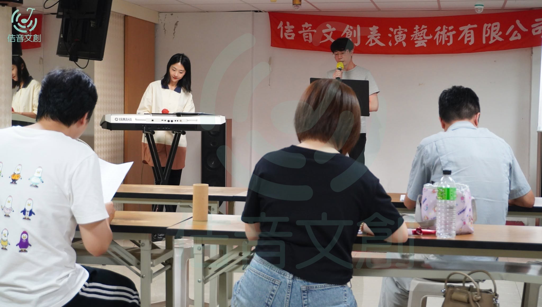 佶音文創成人歌唱班學員手持麥克風練唱流行歌曲